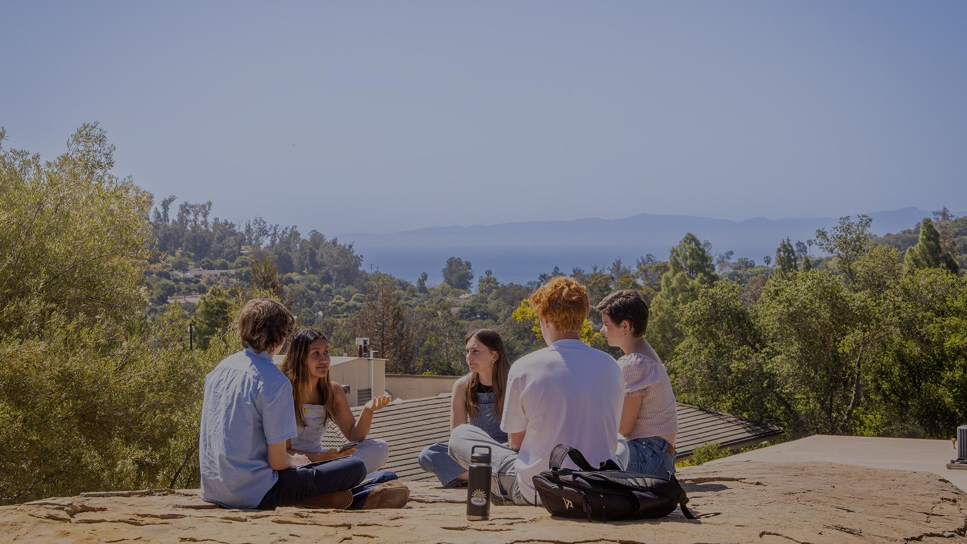 students sitting on a rock first year page